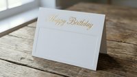 Elegant white greeting card with gold foil Happy Birthday text on rustic wooden surface, luxury stationery for celebration and special occasions.
