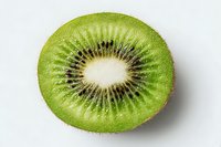 Fresh kiwi fruit slice showing vibrant green flesh and black seeds in circular pattern on white background isolated for healthy food design projects.