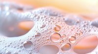 Abstract soap foam bubbles with warm orange and pink gradient background creating dreamy texture for skincare and beauty product designs.