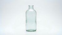 Empty clear glass bottle isolated on white background for packaging design and product mockup applications.