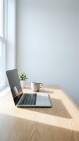 Minimalist home office workspace with laptop computer on wooden desk near window with natural light and small plant for remote work productivity.
