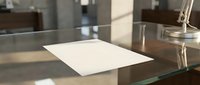 Blank white paper document lying on modern glass desk in contemporary office workspace for business presentations and professional meetings.