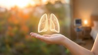 Human hand holding glowing lungs symbol representing respiratory health, medical care and pulmonary wellness in warm sunlight.