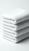Stack of fresh white folded terry towels on light background, conveying cleanliness and luxury for spa, hotel, or bathroom concepts.