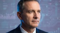 Middle-aged Caucasian male professional in business attire against digital technology background with circuit patterns and data visualization for corporate, tech, and leadership concepts.