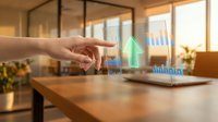 Person's hand interacting with holographic data visualization displaying green upward trending charts and graphs on tablet device in modern office workspace.