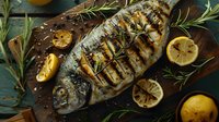 Grilled whole sea bream with charred lemon slices and fresh rosemary sprigs on rustic wooden board. Mediterranean style fish preparation with herbs.