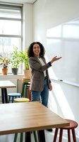 Young Hispanic woman teacher presenting at whiteboard in modern classroom with plants and natural light for education and learning concepts.