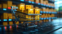 Shopping cart filled with cardboard delivery boxes on laptop keyboard, representing online shopping and e-commerce concept with blurred warehouse background.