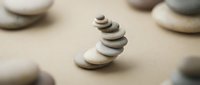 Balanced stack of smooth river stones creating zen meditation arrangement on neutral background for wellness and mindfulness concepts.