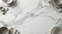 Elegant marble surface with neutral tableware and kitchen utensils arranged around edges, perfect for food photography and culinary content creation.
