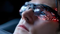 Young Asian woman wearing futuristic smart glasses with red LED light effects and digital display overlay in dark environment, representing advanced technology and augmented reality.