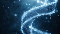Magical glowing particles forming a swirling trail against dark blue background with bokeh effect and sparkles, creating ethereal cosmic atmosphere.