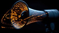 Glowing orange light particles flow through curved fiber optic cable against dark background, creating magical streaming effect for technology and data transfer concepts.