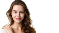 Young Caucasian woman with natural wavy brown hair and gentle smile looking at camera against white background, beauty portrait with soft lighting and clean skin.