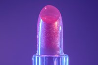 Glowing pink lipstick macro shot with sparkles and glitter particles on purple background, illuminated by neon lights creating dreamy cosmetic atmosphere.
