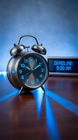 Vintage alarm clock showing deadline pressure with digital display reading 9:00 AM on wooden desk with dramatic blue lighting for business concepts.