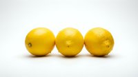 Three fresh yellow lemons with textured skin isolated on white background, ready for food and beverage design projects.
