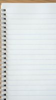 Blank spiral notebook with lined white paper open on a wooden desk, ready for notes, lists, or creative writing.