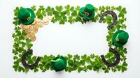 St. Patrick's Day frame with green shamrock clovers, gold coins, leprechaun hats and horseshoes on white background for holiday celebrations and festive designs.