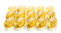 Golden yellow soft gel capsules arranged in rows on white background, omega-3 fish oil vitamin E supplements for health and wellness nutrition.