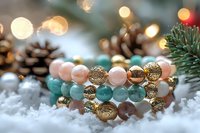 Elegant bracelet with pink and turquoise beads adorned with golden charms on snowy background with pine cones and Christmas lights creating festive bokeh effect.
