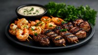 Grilled beef kebabs and seasoned shrimp served on black plate with creamy sauce and fresh herbs. Surf and turf combination showcases perfectly cooked proteins.