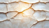 Layered white alabaster stone texture with warm backlight glowing through translucent mineral surface creates dramatic natural pattern and depth effect.