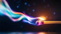 Burning match with colorful smoke trails against dark background, glowing flame and rainbow-colored vapor creating magical atmosphere. Macro photography.