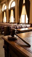 Wooden gavel resting on judge bench in elegant courtroom with classic architecture and warm lighting for legal proceedings and justice concepts.