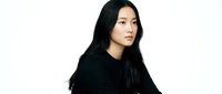 Young Asian woman with long black hair wearing dark clothing on white background for fashion and portrait photography projects.