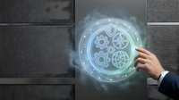 Businessman hand touching glowing holographic gear mechanism interface on dark wall, representing digital transformation, technology innovation, and industrial automation solutions.