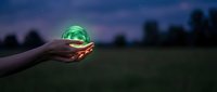 Hands holding glowing green recycling symbol at twilight representing environmental protection and sustainable living practices for eco-friendly business concepts.