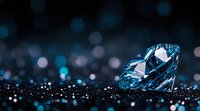 Sparkling blue diamond on dark surface with bokeh lights background creates luxurious atmosphere. Precious gem reflects light with brilliant cut facets.