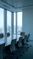 Modern corporate boardroom with panoramic city skyline view through floor-to-ceiling windows. Executive meeting space with conference table and leather chairs.