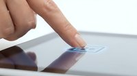 Finger touching a glowing button on a modern tablet screen, close-up shot highlighting digital interaction and touchscreen technology in everyday use.