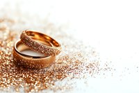 Golden wedding rings with sparkling diamonds on glittery rose gold background, romantic luxury jewelry composition for marriage ceremony and engagement.