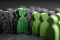 Wooden figures in green and black colors representing team diversity, leadership concept, and business collaboration for corporate presentations.