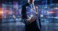 Professional businessman in suit holding glowing geometric cube with digital financial charts and data analytics interface for technology presentations.