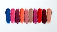 Colorful lipstick smear swatches arranged in a row on white background, showcasing a vibrant palette of shades for beauty and makeup concepts.