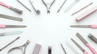 Professional manicure tools arranged in circle on white background. Nail care equipment including files, clippers, cuticle pushers for salon services.