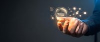 Businessman hand holding glowing digital sphere with network connections and success concept icons, representing business growth and innovation strategy.