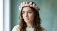 Young woman with curly brown hair wearing pink hair rollers and cream sweater, beauty routine and hair styling concept for salon and personal care.