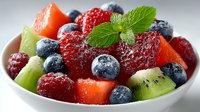 Fresh fruit salad with strawberries, blueberries, kiwi, watermelon and mint garnish in white bowl, healthy breakfast option for clean eating and detox diets.
