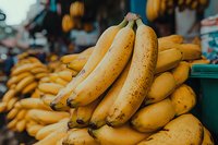 Fresh ripe yellow bananas stacked at local market produce stand, close-up view showing natural spots and texture, suitable for healthy eating concepts.