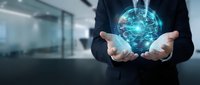 Businessman holding glowing digital brain hologram with network connections in modern office environment representing artificial intelligence and innovation.