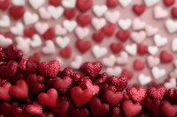 Red and white glittery hearts creating romantic bokeh background pattern with selective focus on shimmering crimson hearts in foreground, soft dreamy Valentine's day composition.