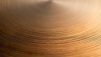 Close-up macro view of copper wire coils with warm golden tones and shallow depth of field creating abstract industrial texture for electrical projects.