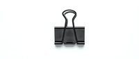 Black metal binder clip isolated on white background for office supplies, document organization and business paperwork needs.
