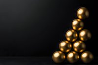 Golden spheres arranged in triangular formation against dark background create minimalist composition with dramatic lighting and luxurious metallic finish.